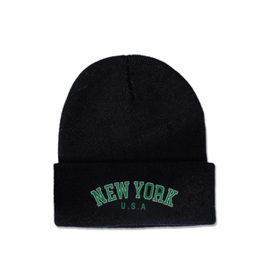 Detail shot of the green embroidered NEW YORK USA text on a black ribbed knit beanie