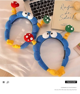 Detail of plush cartoon headbands in blue with colorful dots on a soft white fabric