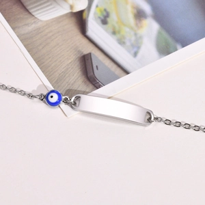 Detail shot of silver evil eye bracelet with polished blank engravable ID plate