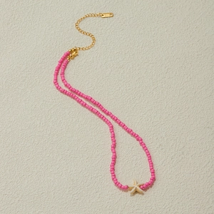 Detailed macro view of pink seed bead necklace featuring a white shell starfish pendant
