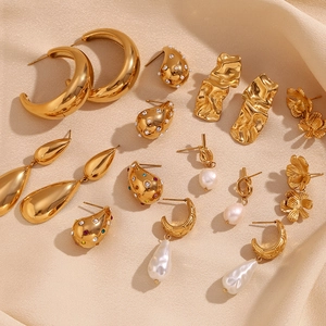 Golden 18K plated drop earrings and geometric stud collection on silk background