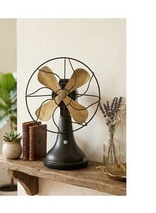 Retro decorative iron fan model on a rustic wooden shelf with vintage props and books