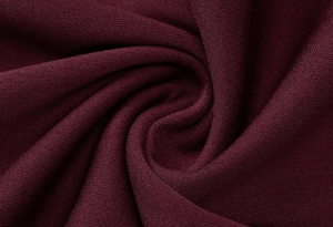 Vue détaillée de la texture du tissu tricoté rouge vin lisse avec plis élégants