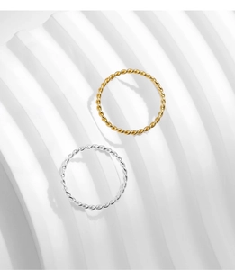Detail shot of minimalist silver and gold twisted rope stackable rings on white display