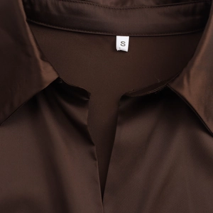 Detail view of the brown satin shirt collar featuring a standard lapel and size S label