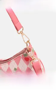 Détail du motif cerise sur texture matelassée avec boucles métalliques dorées