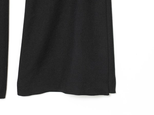 Detailed close-up of the twill woven texture and hem of these black trousers
