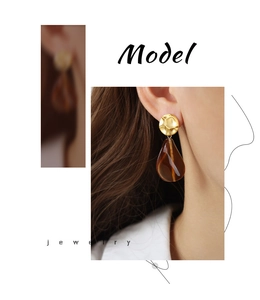 Detail showing vintage gold textured stud and amber teardrop resin earring on model