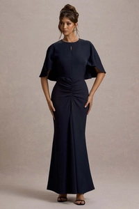 Dettaglio di un abito attillato blu navy con pieghe in vita ed elegante collo a mantella