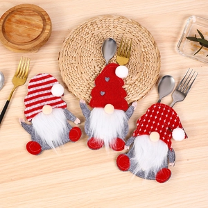 Three-piece gnome Christmas cutlery holder set with red and grey felt on wooden table