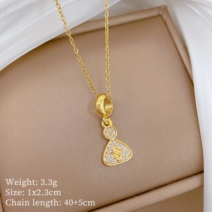 Macro shot of gold triangular letter S pendant with pavé diamonds in a jewelry box