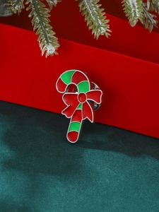 Broche canne de Noël avec nœud rouge sur fond élégant en velours vert foncé