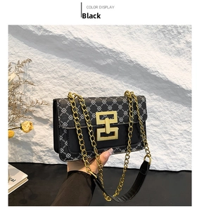 Détail du sac bandoulière noir avec motifs trèfles blancs et chaîne dorée