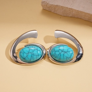 Detailed shot of silver textured hoop earrings with oval turquoise resin inlay stones