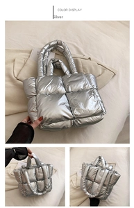 Detail of silver metallic quilted puffer tote bag featuring square padded stitch patterns