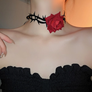 Detail eines dunklen Gothic-Chokers mit roter Rose und schwarzem Dornenwickel