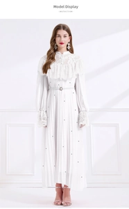 Détail de la robe vintage en dentelle blanche avec texture plissée et ceinture perle