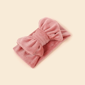 Close-up of pink corduroy baby headband featuring a soft textured vertical ribbed bow