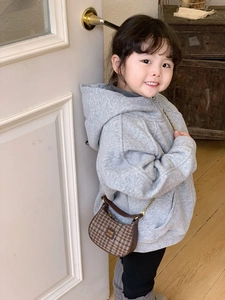 Détail du sac hobo enfant à carreaux avec chaîne dorée sur un sweat à capuche gris