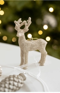 Détail d'un renne de Noël doré scintillant suspendu à un sapin avec des paillettes