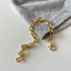 Detailed close-up of 925 sterling silver lobster clasp on gold-plated chain bracelet