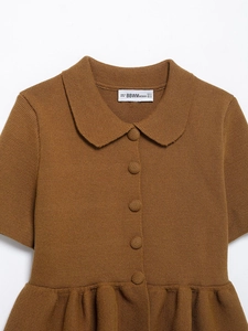 Detailed view of brown knit top featuring a Peter Pan collar and textured single-breasted buttons