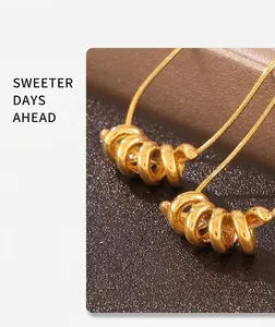 Detailansicht des goldenen Spiralanhängers an einer feinen Schlangenkette