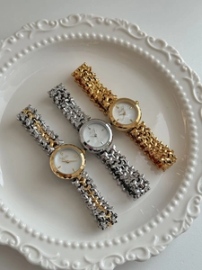 Tre eleganti orologi in metallo vintage con quadranti in madreperla su un piatto bianco