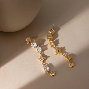 Détail des boucles d'oreilles étoile à glands en or 18 carats avec oxydes de zirconium