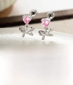 Macro detail of silver bow earring with pink heart zircon and size dimensions