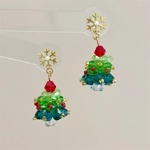 Detailed beaded Christmas tree earrings with a festive red bow and gold snowflake hook