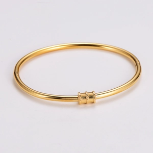 Close-up of golden stainless steel bangle featuring three textured diamond-cut cylinders