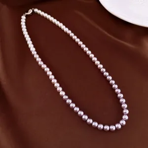 Elegant gradient pearl necklace with white and lilac beads and heart clasp on satin