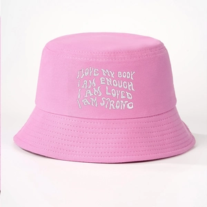 Close-up of pink cotton bucket hat featuring white embroidered inspirational slogans