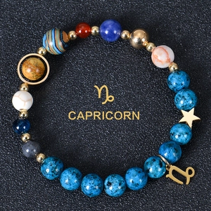 Detailed macro view of Capricorn zodiac bracelet with blue natural stones and gold star charms