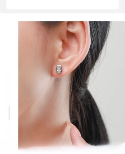 Close-up of S925 sterling silver oval stud earring with inset cubic zirconia on ear