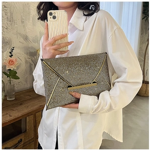Vue détaillée de la pochette enveloppe à paillettes or champagne avec garniture métallique