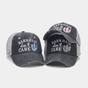 Close-up of three distressed mesh baseball caps with Barn Hair Don't Care embroidery