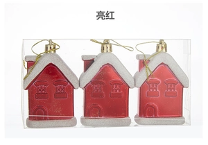 Detailed view of three bright red snow house ornaments with gold strings and frosty snow