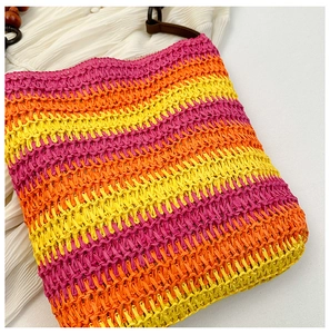 Detail of handmade rainbow straw bag featuring wooden beads and colorful paper fiber texture