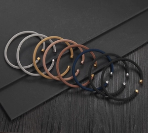 Detailed view of woven metal mesh bracelets in various colors with cylindrical end caps