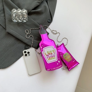 Pink holographic ketchup bottle shaped crossbody bag set with silver chain strap on white surface