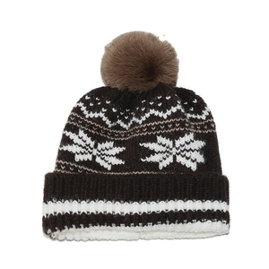 Detailed knit texture of a brown winter hat featuring white snowflakes and fluffy pompom