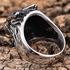 Gothic wolf head ring in vintage silver finish displayed on natural tree bark texture
