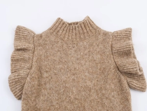 Detail of warm camel knit sweater featuring ribbed mock neck and ruffled cap sleeve design