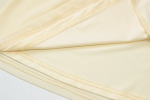 Makrodetail der hochwertigen Overlock-Naht und glatten gelben Stofftextur