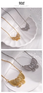 Detail view of the intricate zircon micro-paving on butterfly pendants in gold and silver
