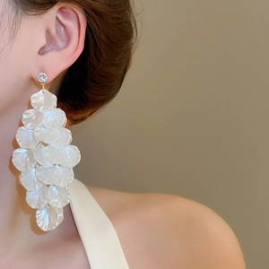 Detail of layered white petal tassel earrings with zircon stud shown on model