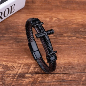 Close-up of a dark brown braided leather bracelet featuring a black metal cross and magnetic clasp