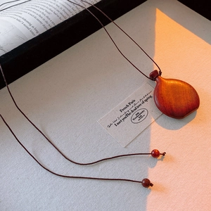 Macro shot of retro wooden wine gourd pendant with hand-woven rope on a vintage book